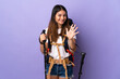 © luismolinero - Young woman with backpack and trekking poles isolated on purple background counting five with fingers