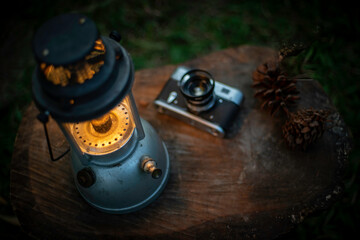 Light of an antique oil lamp on a wooden floor in the black background at night, camping in the forest.shallow focus effect.soft focus.