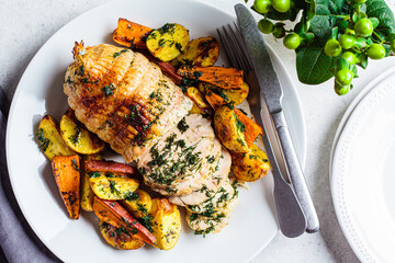 Stuffed chicken breast roll served with potato and sweet potato garnish on the festive table.