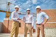 © zinkevych - Three men communicating at construction site