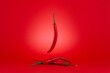 Three of Chili peppers isolated on red background.