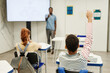 © Seventyfour - Back view portrait of African-American child raising hand in classroom, copy space