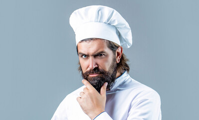 Serious cook in white uniform, chef hat. Portrait of a serious chef cook. Bearded chef, cooks or baker. Bearded male chefs isolated. Cook hat