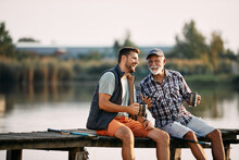 Cheerful Man And His Senior Father Have Fun While Fishing From Pier.