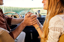 Rear View On Caucasian Adult Couple Sitting In Old Vintage Classic Van, Romantic Time Together, Drinking Tea. Concept Of Vanlife And Travel People, Changing Life Man And Woman, Close-up Hands