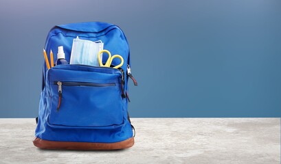 Wall Mural - Backpack with different colorful stationery on the table.