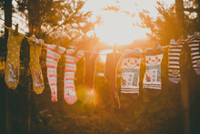 Five Pairs Of Novelty Socks Hanging On A Clothes Line Drying In Sun