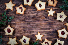 Overhead View Of Christmas Linzer Cookies Filled With Raspberry Jam On A Wooden Table