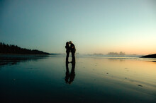 Senior Couple Standing On An Empty Beach Kissing, British Columbia, Canada