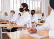 © JackF - Woman studying in classroom with colleagues medicals in protective face masks for disease prevention during training program for health workers