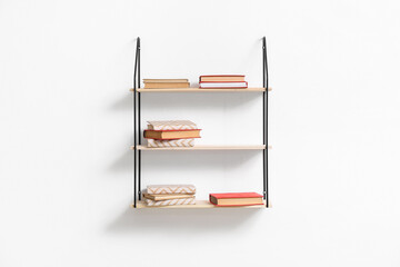 Modern shelves with books hanging on light wall