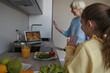 © Svitlana - Grandma and child making dinner and videocalling loved ones