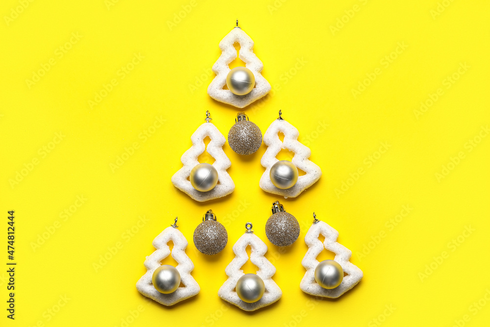 Christmas tree made of decorations on yellow background
