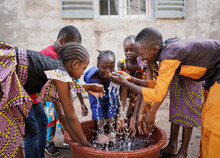 Group Of African Children Play With Fresh Water