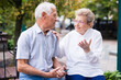 © caftor - mature man with a woman sitting on bench in spring