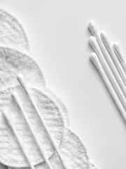 Wall Mural - Cotton swabs for cleaning ears on cotton pads for removing make up and washing face on white background with space for text with selective focus