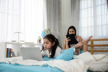 child girl person 2 sisters watching media and learning on laptop, online communication at home