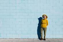 Positive Elderly Woman In Hat Near Wall
