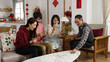 © PR Image Factory - asian family taking turns discarding card on table while playing poker during spring festival at home. excited mother talking with gestures. chinese text translation: spring and congratulations