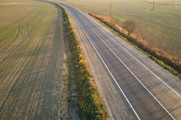 Canvas Print - Aerial view of empty intercity road at sunset. Top view from drone of highway in evening