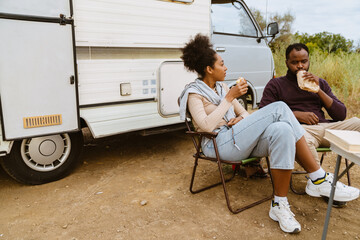 Wall Mural - Black couple eating sandwiches during journey on trailer