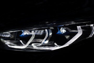 Detail close up view of the LED adaptive head light of premium luxury sedan car. Automotive lighting technology detail.