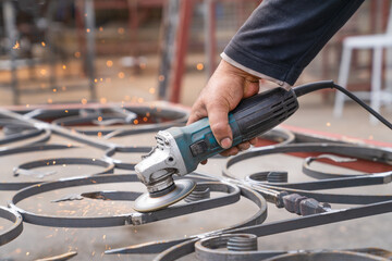 Metal grinding with angle grinder. Male hand and instrument close-up, side view.