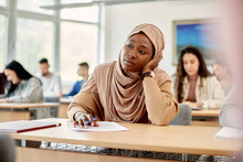 African American Islamic Student Feels Bored During Lecture At University Classroom.