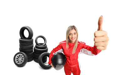 Poster - Female racer making a thumb up sign in front of car tires