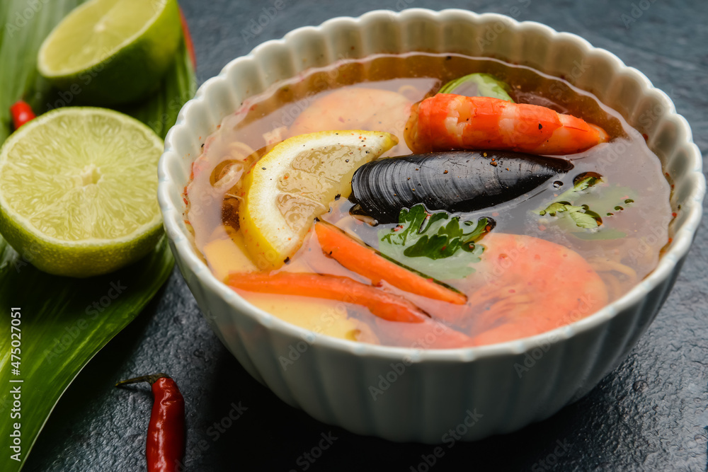 Bowl of spicy Thai soup on dark background
