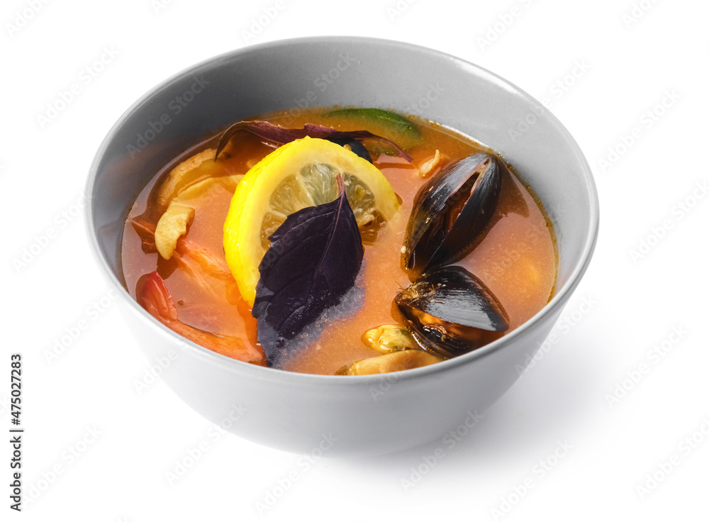 Bowl of spicy Thai soup on white background