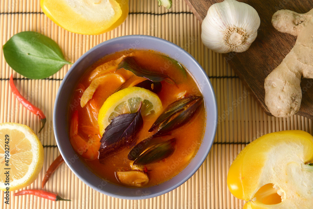Bowl of spicy Thai soup on table