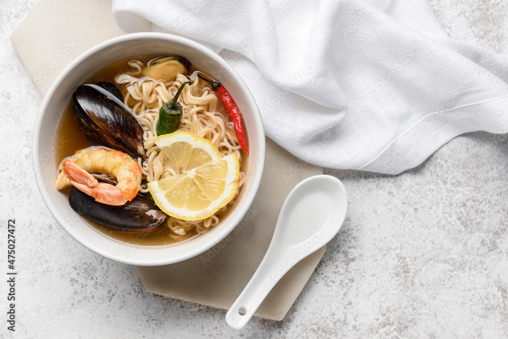 Bowl of spicy Thai soup on grunge background