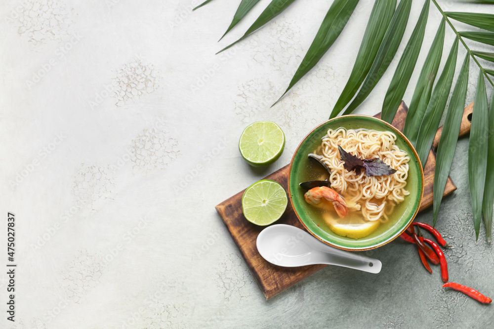 Bowl of spicy Thai soup on grunge background
