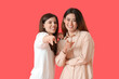© Pixel-Shot - Young gossiping women on color background