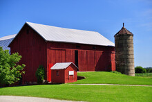 A Red Barn In The Midst Of Amish Country In Northeastern Indiana. The Old Wooden Red Barn Standout Within The Green Of A Mid-summer Day.