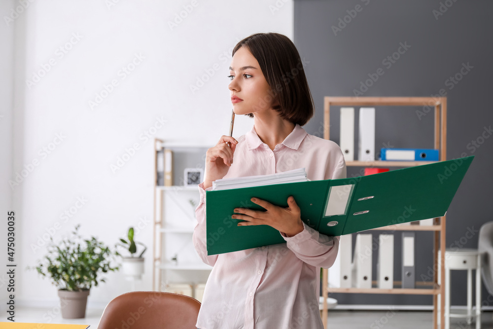 Young woman working with documents in office