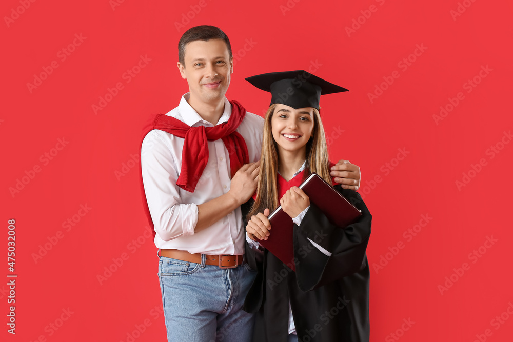 Happy female graduation student with her father on color background