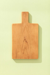 Canvas Print - Handmade cherry wood wooden cutting board on light green background.