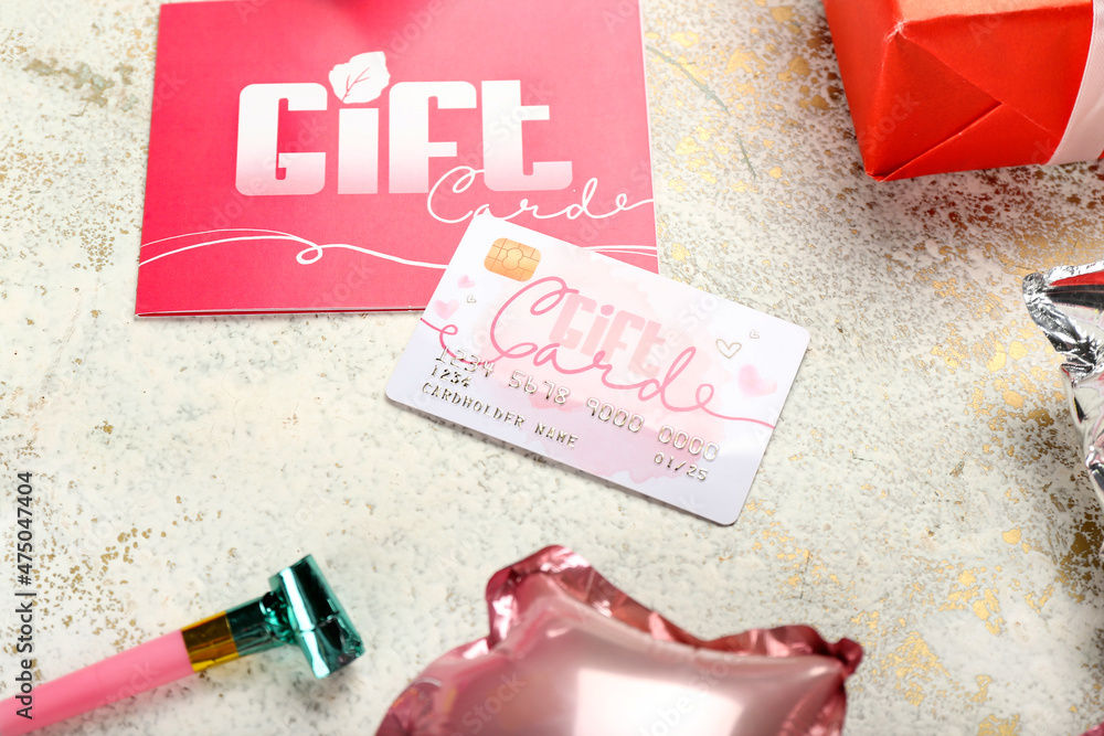Gift card, whistle, balloons and present on light table