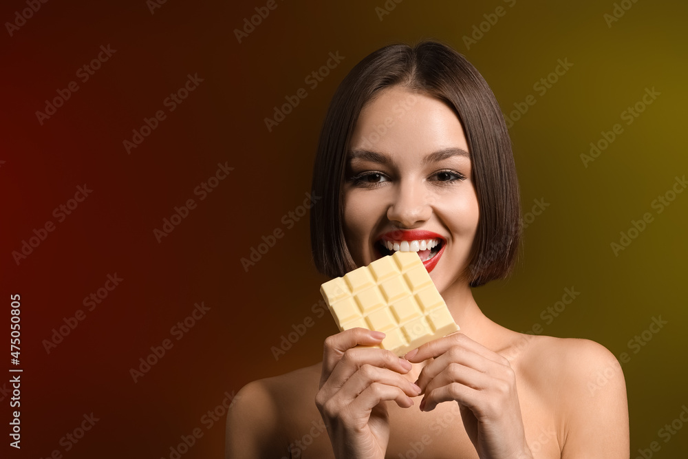 Beautiful woman with sweet chocolate on dark background