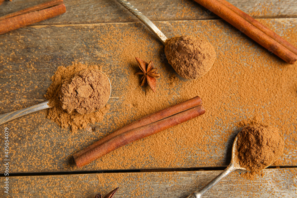 Composition with cinnamon sticks, powder and star anise on wooden background