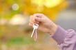© Pixel-Shot - Woman holding key on chain outdoors