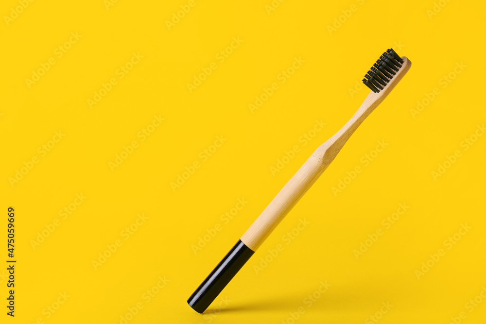 Wooden toothbrush on yellow background