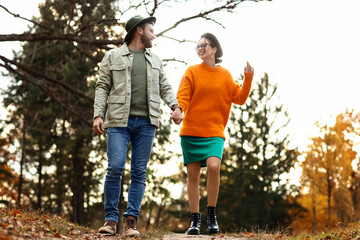 Sticker - Beautiful couple holding hands and walking in autumn park