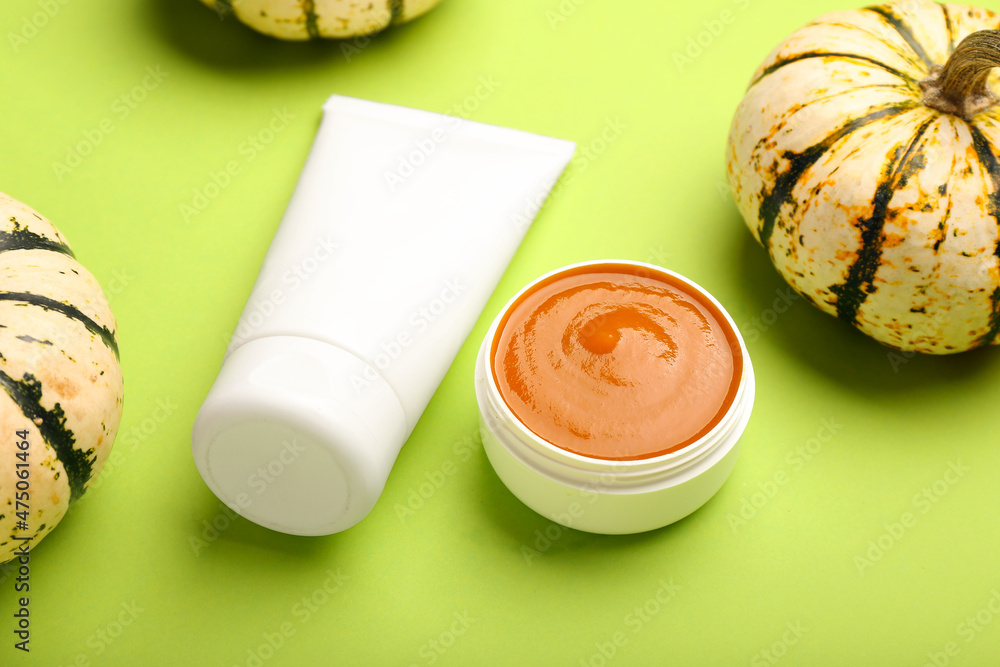 Natural pumpkin cosmetics on green background