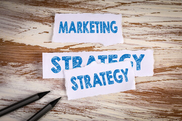 Wall Mural - marketing strategy. torn sheets of paper on a wooden background