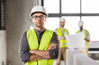 © Syda Productions - architecture, construction business and building concept - male architect in helmet and safety west at office
