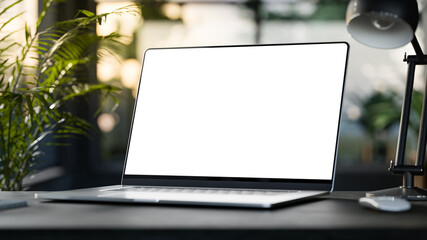 Wall Mural - laptop with blank frameless screen mockup template on the table in industrial office loft interior -