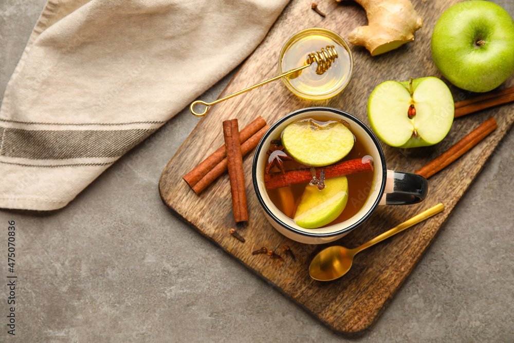 Cup of tasty fruit tea with cinnamon on grey background